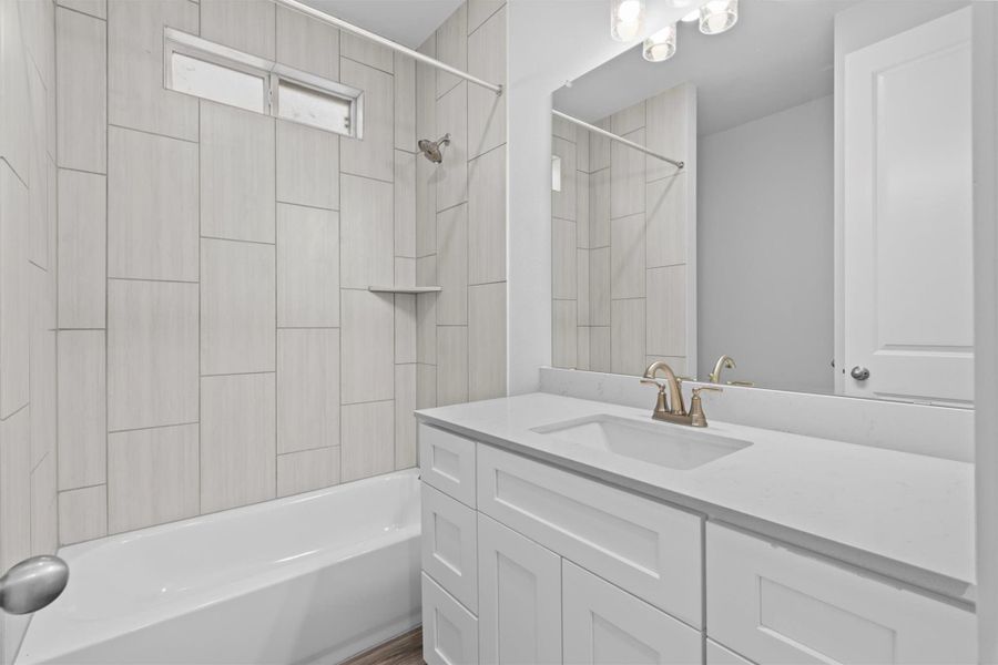 Bathroom featuring tiled shower / bath combo and vanity