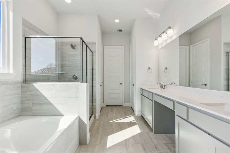 Bathroom with hardwood / wood-style flooring, vanity, and independent shower and bath