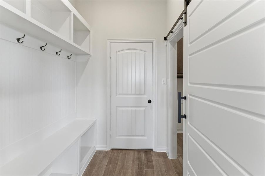 Mudroom with a barn door and dark wood-style floors Mudroom with a barn door and dark wood-style floors