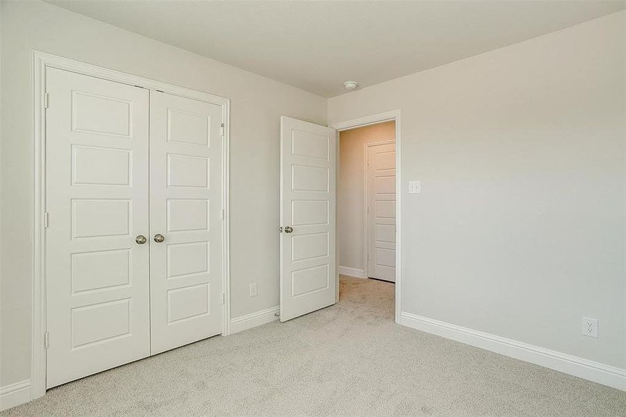 Unfurnished bedroom featuring carpet, a closet, and baseboards