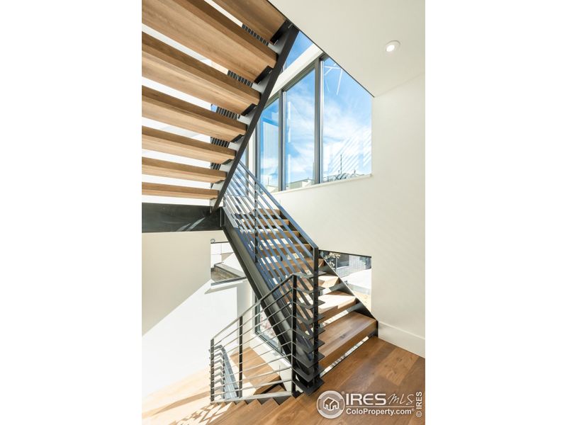 The architecturally stunning floating staircase features open 4" block treads and walls of windows that bring in abundant natural light.
