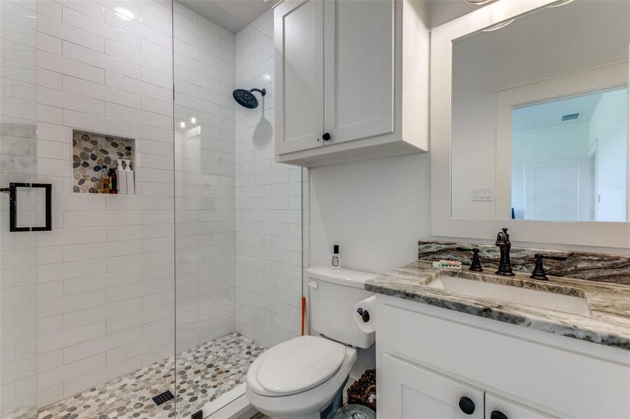 Bathroom with tiled shower, toilet, and large vanity Bathroom with tiled shower, toilet, and large vanity