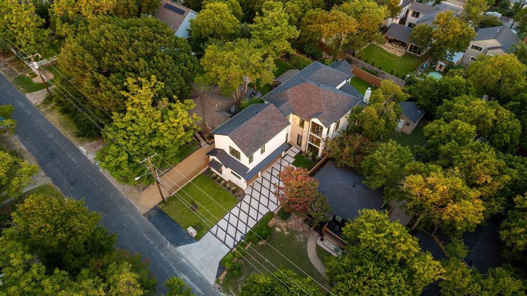 Contemporary residence featuring a light-toned facade and dark-pitched roofing