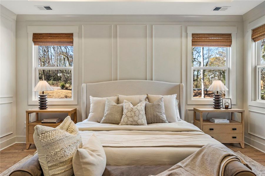 This spacious bedroom offers serene views and a tr