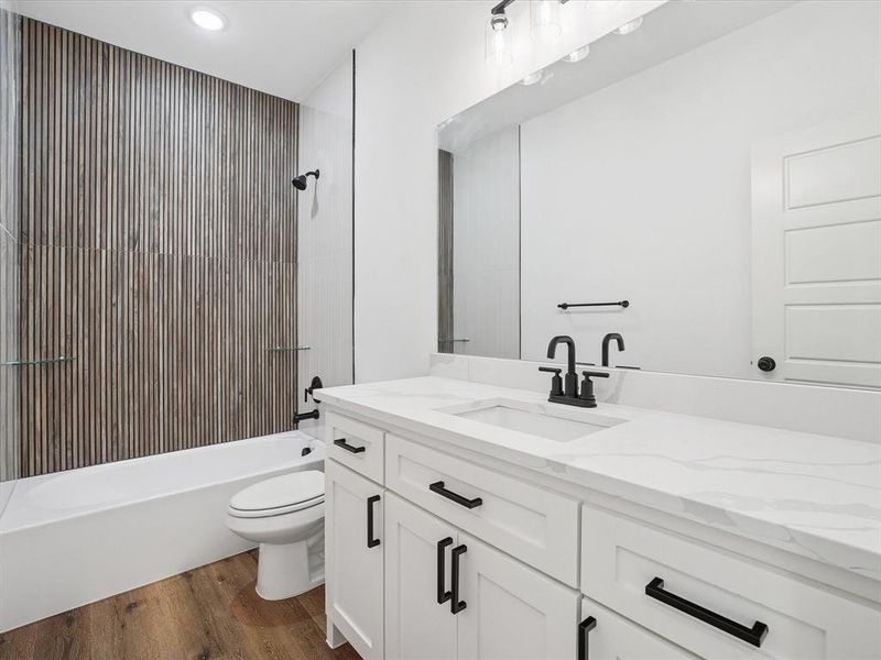 Full bathroom featuring vanity, dark wood-style flooring, and washtub / shower combination