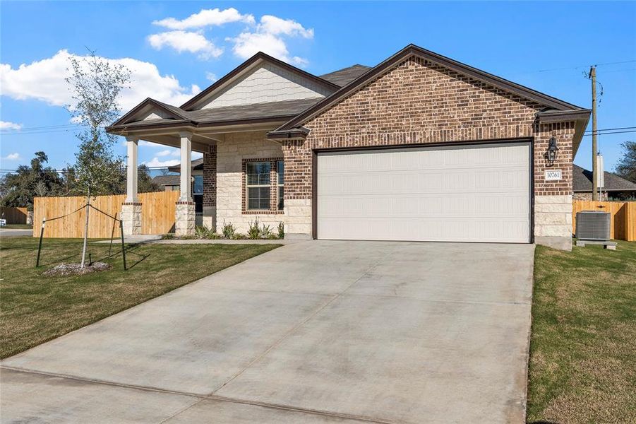 View of front of property with brick siding, a porch, driveway, and an attached garage