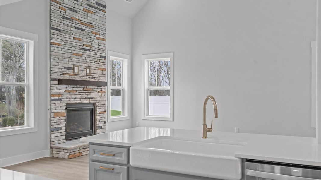 Highly skilled kitchen design includes a 9-foot island, quartz countertops, and stylish pendant fixtures