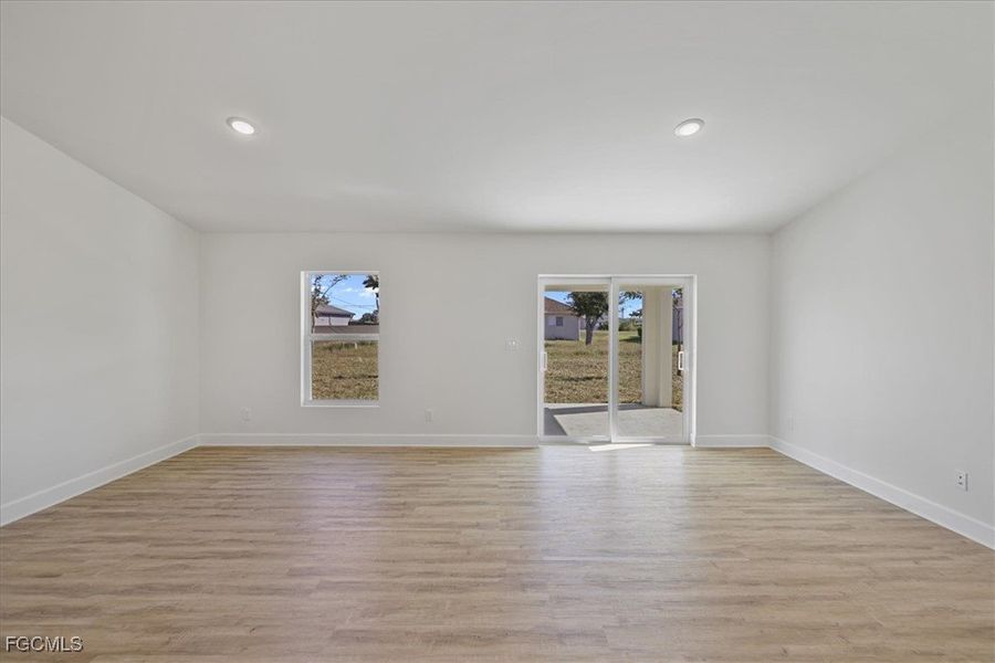 Empty room featuring light wood finished floors and recessed lighting