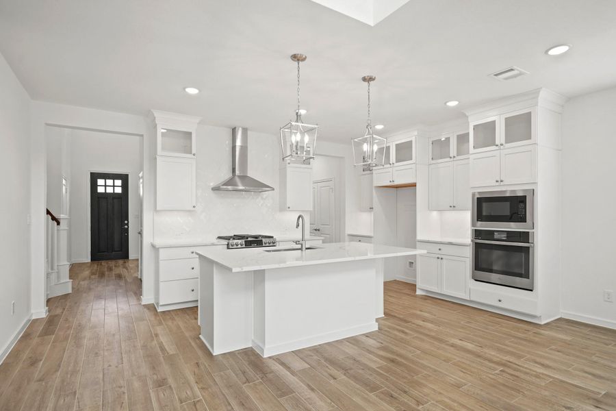 Gourmet island kitchen with white stacked cabinets and quartz countertops (*Photo not of actual home and used for illustration purposes only.) Gourmet island kitchen with white stacked cabinets and quartz countertops (*Photo not of actual home and used for illustration purposes only.)