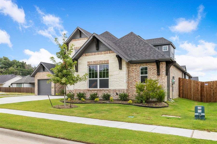 View of front of property featuring a garage and a front yard