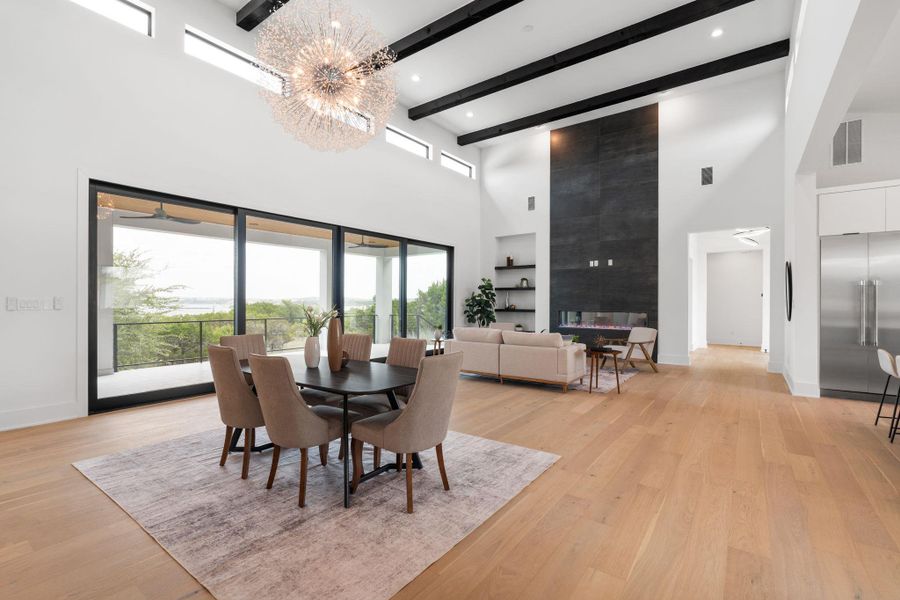 A grand open-concept living area with a dramatic fireplace and sweeping outdoor views.