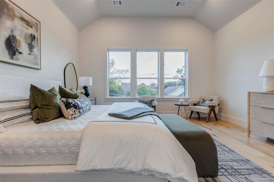 Alternate view of the primary bedroom showing the generous floor space and modern recessed lighting, accentuating the room’s clean architectural lines and open feel.