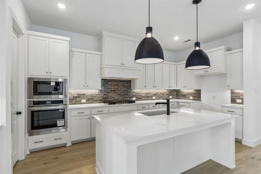 Featuring ample storage and prep space plus a spacious center kitchen island, this gorgeous kitchen checks all the boxes!