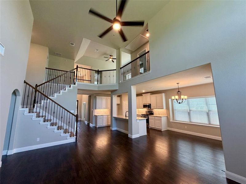 Amazing great room with rich REAL heardwood floors, cathedral ceiling, and wrought iron spindles in stairs