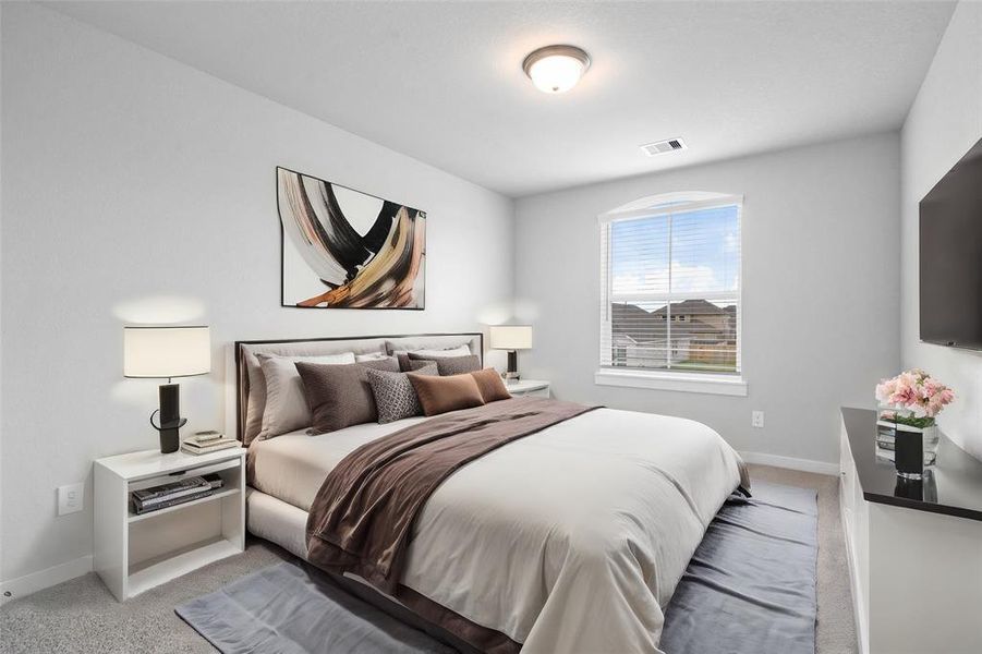 Secondary bedroom features plush carpet, neutral paint, lighting and a large window with privacy blinds.