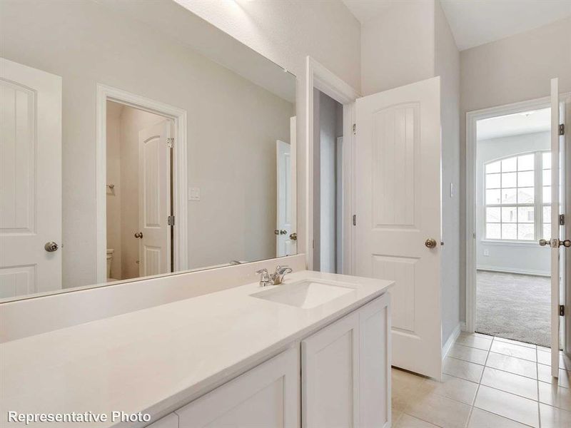 Bathroom with an extended vanity featuring a white countertop, an integrated sink, and a large mirror
