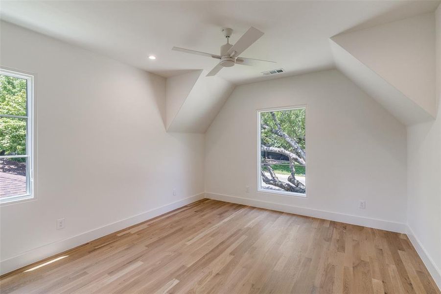 Additional living space with light wood-style flooring, vaulted ceiling, ceiling fan, and recessed lighting Additional living space with light wood-style flooring, vaulted ceiling, ceiling fan, and recessed lighting