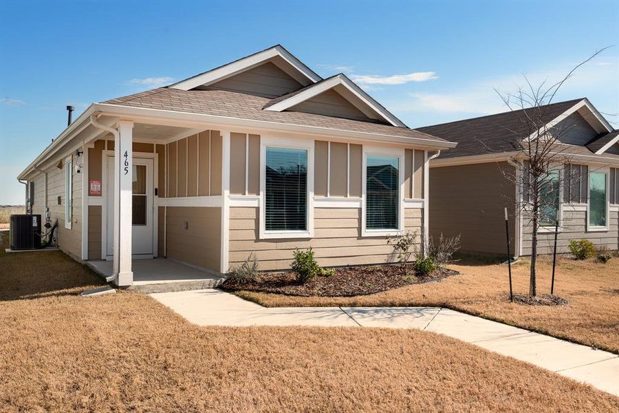 View of front of house featuring a front yard and central AC