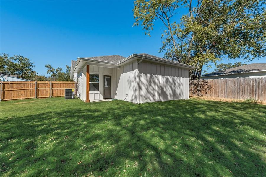 Back of property with a fenced backyard, board and batten siding, and a shingled roof Back of property with a fenced backyard, board and batten siding, and a shingled roof