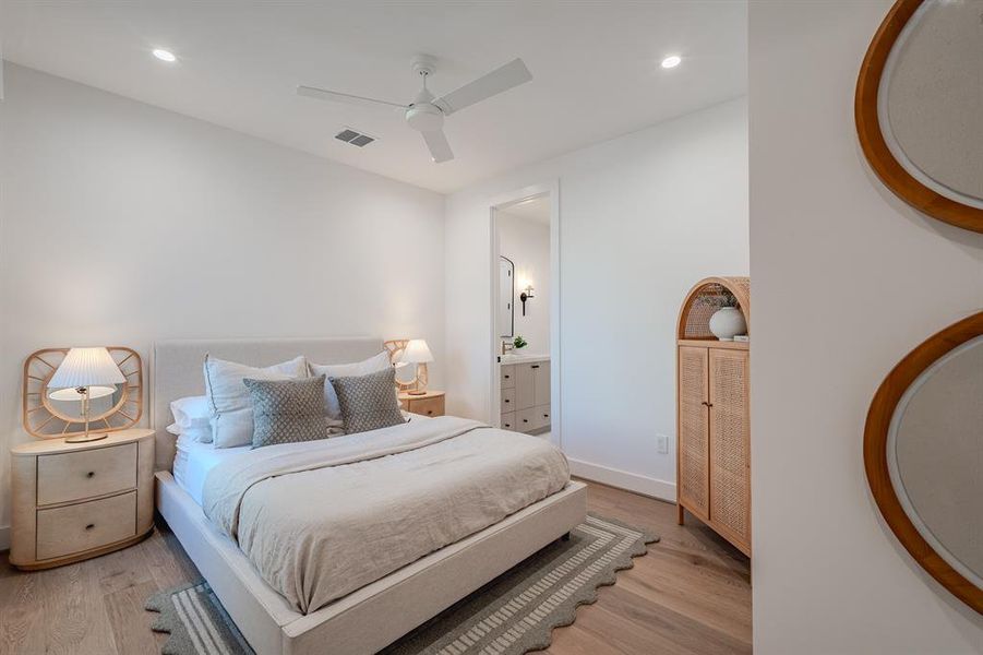 Bedroom featuring light wood-style floors, a ceiling fan, recessed lighting, and ensuite bath