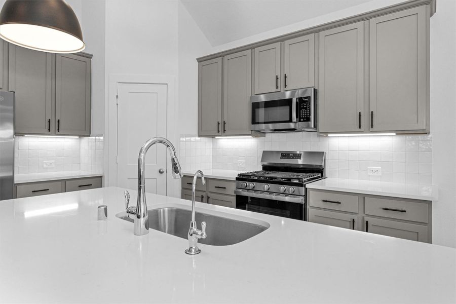 This view highlights the kitchen’s ample counter space, offering a functional and stylish setting for cooking and hosting.