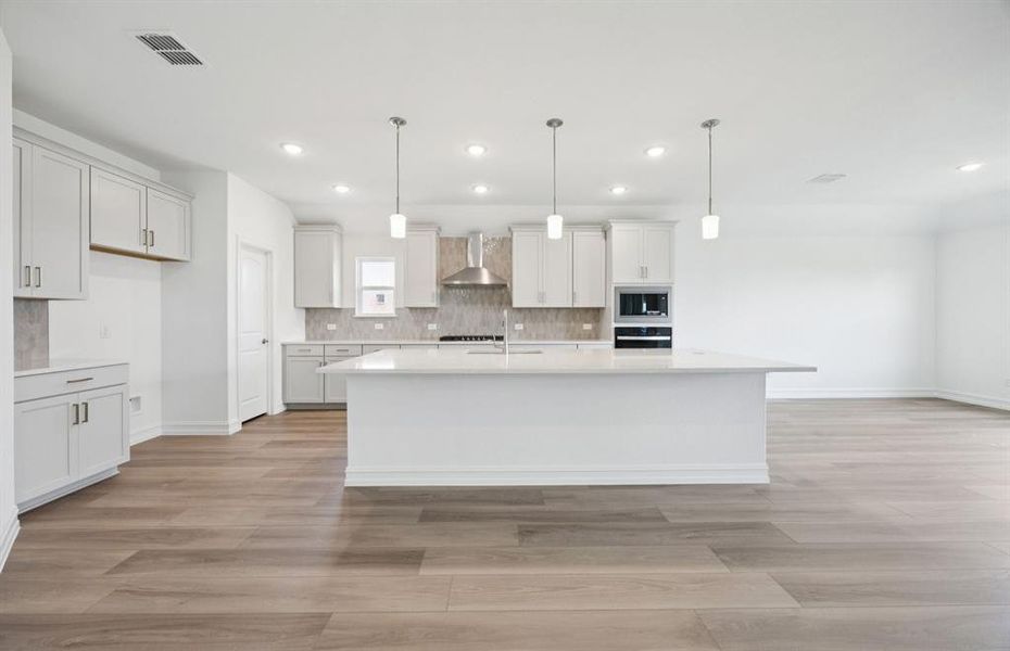 Large island overlooking gathering room and dining areas