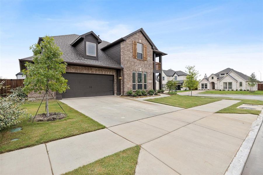 View of front of home with roof with shingles, driveway, brick siding, an attached garage, and a residential view
