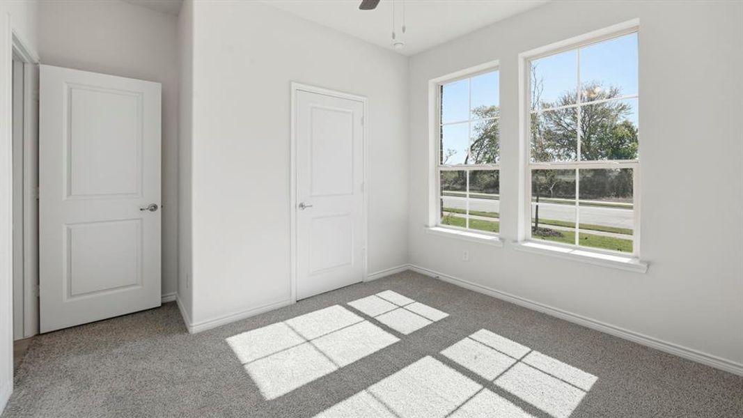 Unfurnished bedroom with light carpet and ceiling fan Unfurnished bedroom with light carpet and ceiling fan