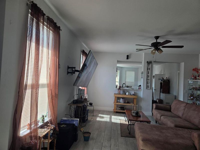 Living room featuring plenty of natural light, wood finished floors, and a ceiling fan