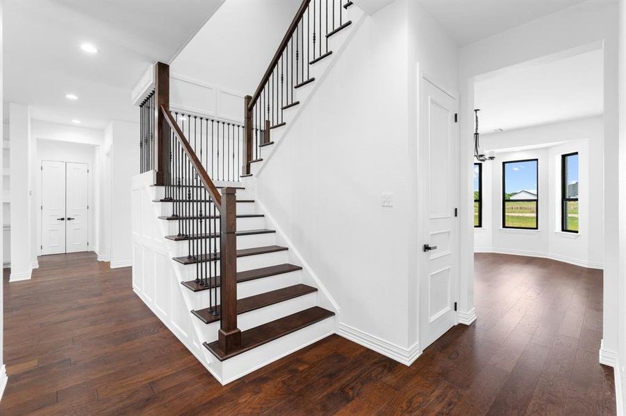 Stairs with wood finished floors, recessed lighting, and a chandelier Stairs with wood finished floors, recessed lighting, and a chandelier