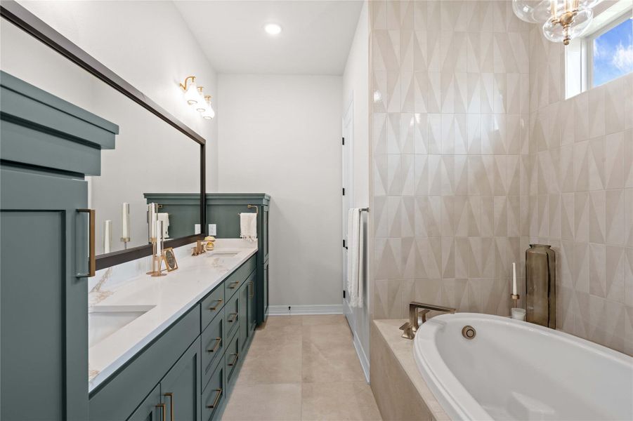 Luxurious primary bath with a deep soaking tub and an extended dual vanity featuring ample storage. Luxurious primary bath with a deep soaking tub and an extended dual vanity featuring ample storage.