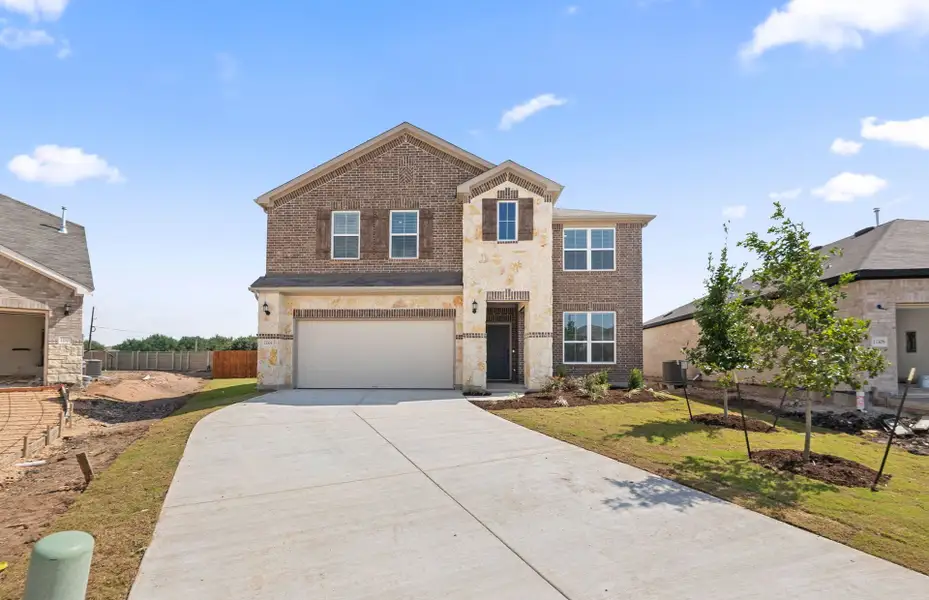 Front exterior of a new home in Lagos, Manor, TX, highlighting curb appeal (Image 24). Front exterior of a new home in Lagos, Manor, TX, highlighting curb appeal (Image 24).