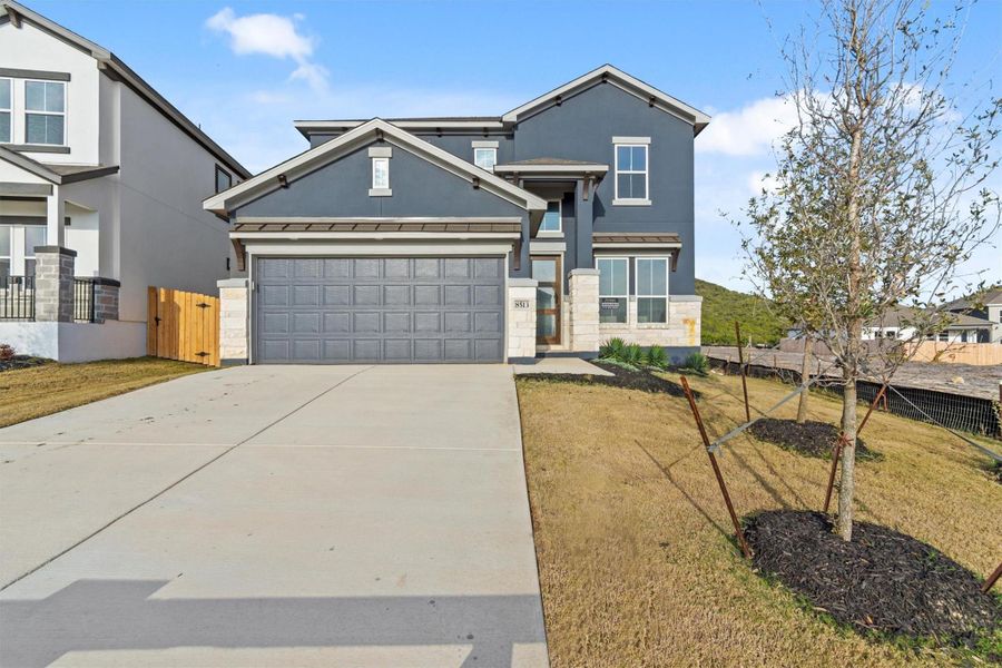 View of front of property with a garage and a front lawn