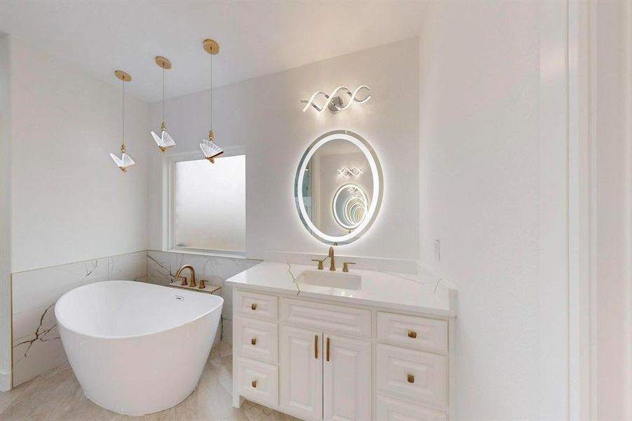 Bathroom with tile walls, a freestanding bath, vanity, and a wainscoted wall