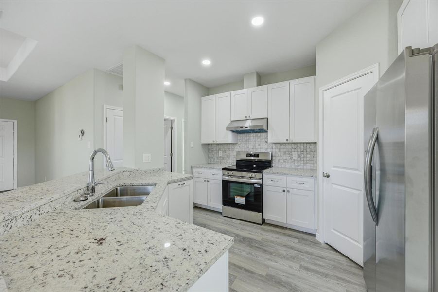 A well-lit kitchen presents a functional layout with ample counter space and contemporary appliances.