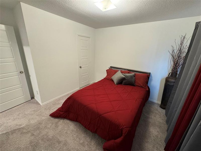 Carpeted bedroom with a textured ceiling