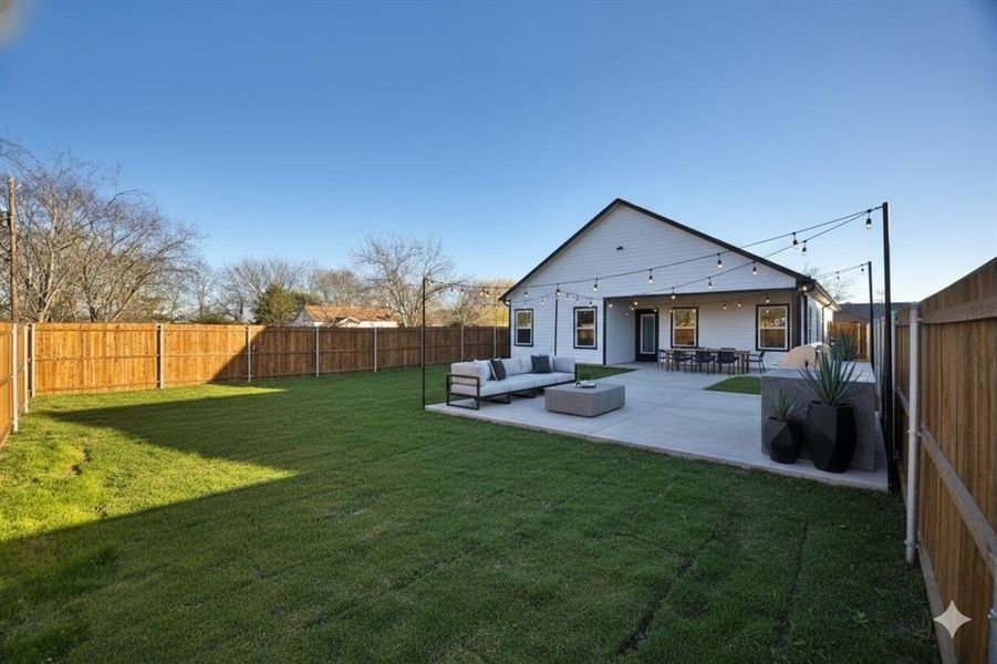 Back of house with a fenced backyard, outdoor seating, and a patio area