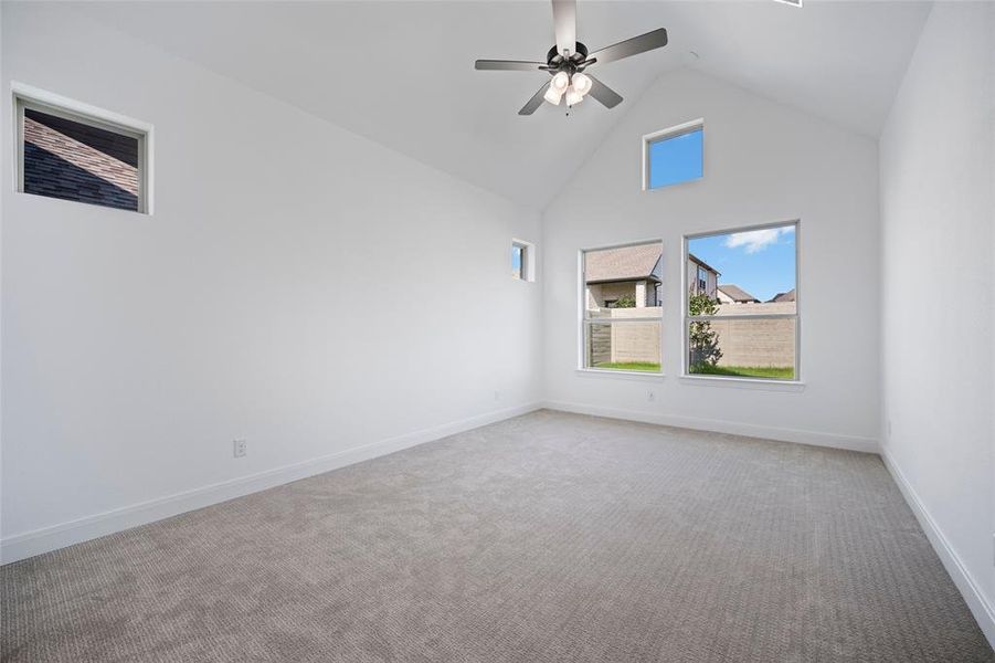 Unfurnished room with carpet floors, ceiling fan, and high vaulted ceiling