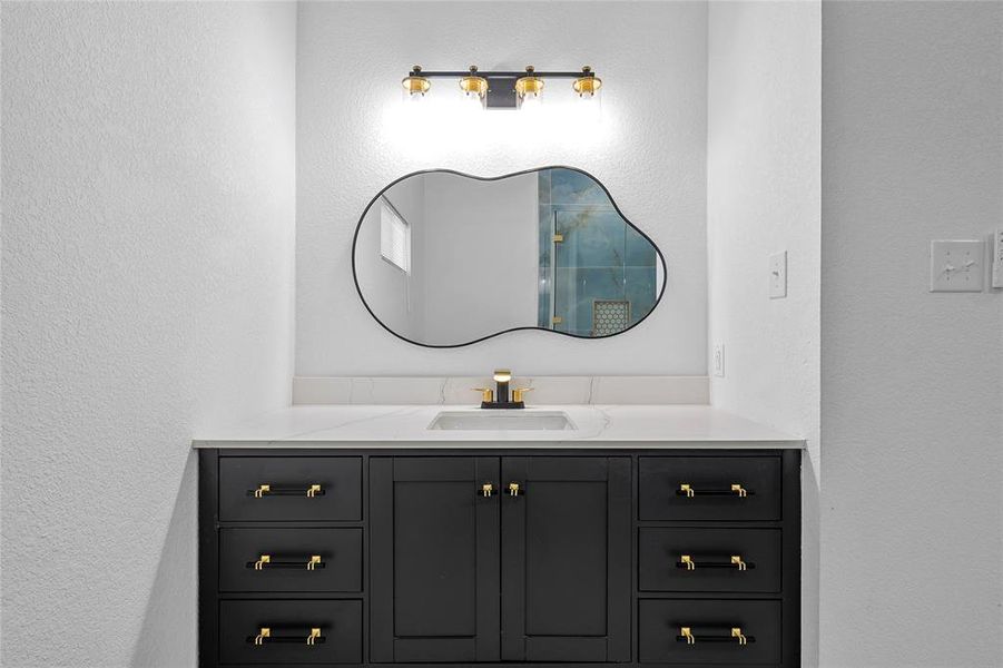 Modern vanity with a black cabinet base and gold-tone hardware Modern vanity with a black cabinet base and gold-tone hardware