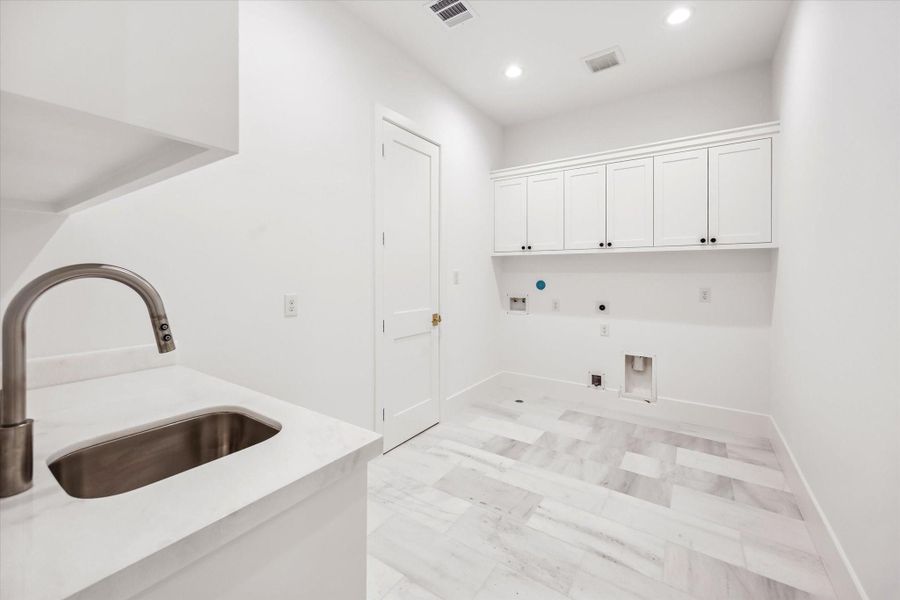 Generous utility space designed for everyday efficiency, featuring a deep sink, stone countertops, and upper cabinetry for concealed storage. Layout allows room for full size appliances while keeping tasks organized and out of sight.**Previous build by Arch Angelo** Generous utility space designed for everyday efficiency, featuring a deep sink, stone countertops, and upper cabinetry for concealed storage. Layout allows room for full size appliances while keeping tasks organized and out of sight.**Previous build by Arch Angelo**
