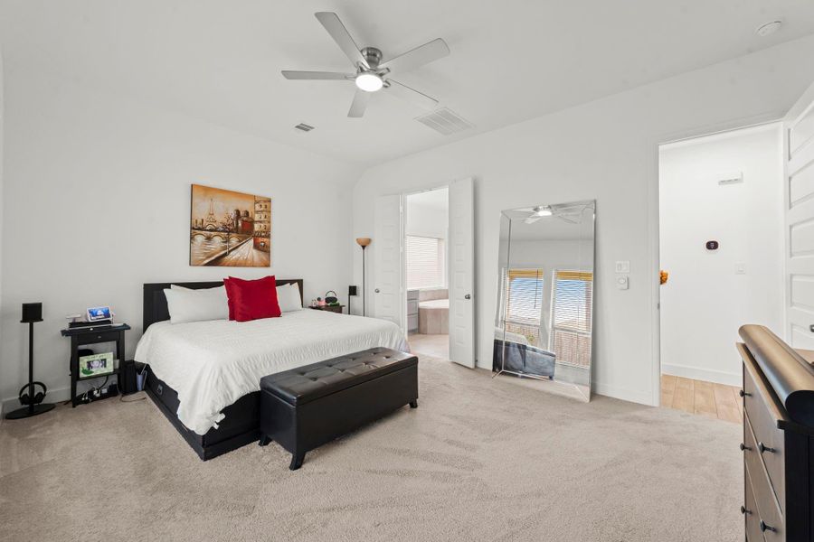 Located in the rear of the home away from the other bedrooms, the primary bedroom offers both elegance and tranquility. The sightline into the en-suite bath showcases upscale finishes and thoughtful design, elevating the suite into a true luxury escape.