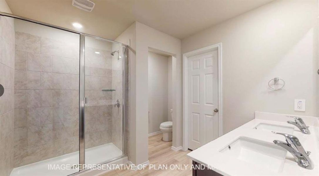 Full bath featuring double vanity, a shower stall, light wood-style floors, and recessed lighting