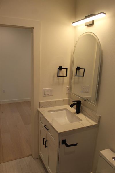 A sleek vanity with a rectangular sink and elegant black fixtures anchors this well-appointed bathroom.