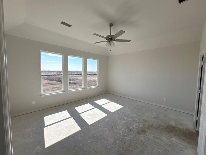Spare room with a ceiling fan and concrete flooring
