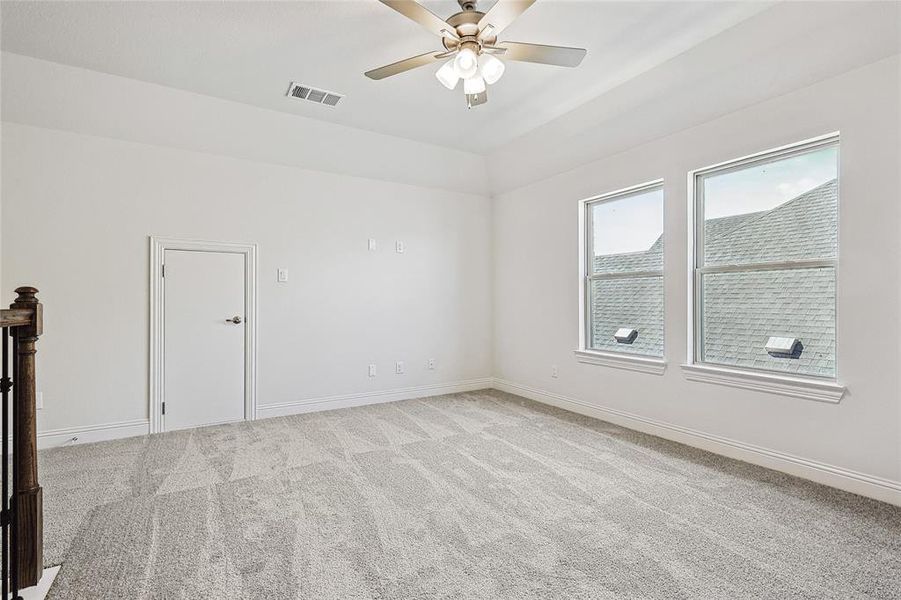 Unfurnished room with ceiling fan and light colored carpet