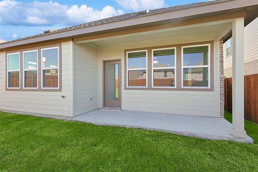 Rear view of property featuring a yard and a patio