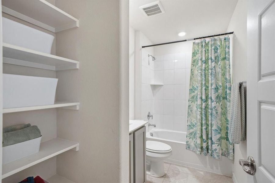 Bathroom featuring vanity, shower / bath combo with shower curtain, and light tile patterned flooring Bathroom featuring vanity, shower / bath combo with shower curtain, and light tile patterned flooring