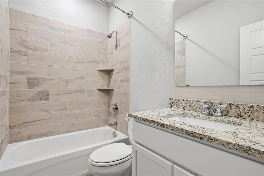 Bathroom featuring  shower combination, vanity, and a textured wall