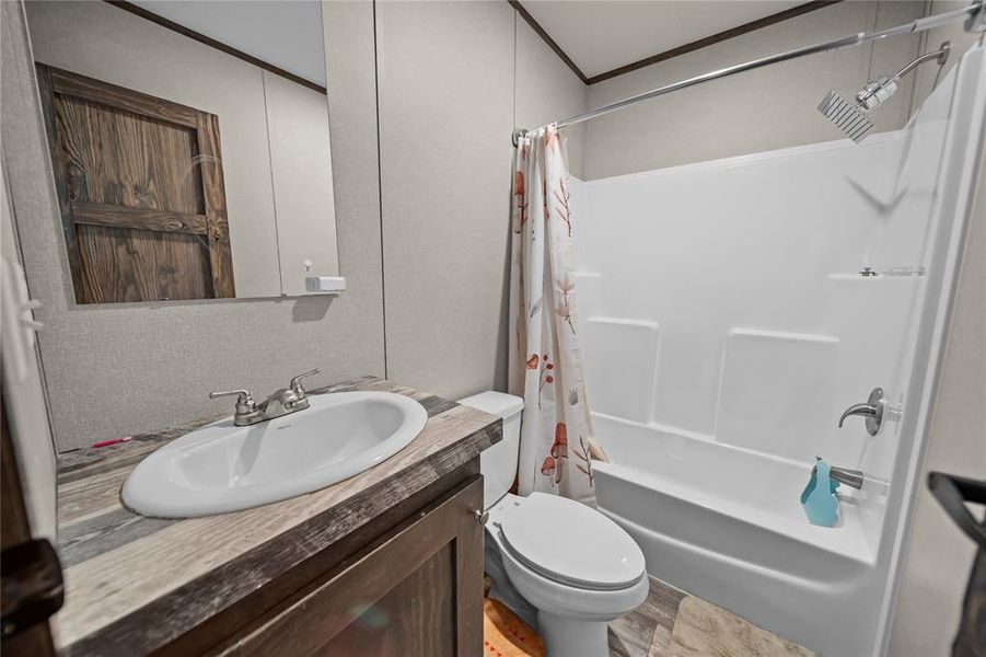 Full bathroom featuring shower / bath combo, vanity, and ornamental molding Full bathroom featuring shower / bath combo, vanity, and ornamental molding