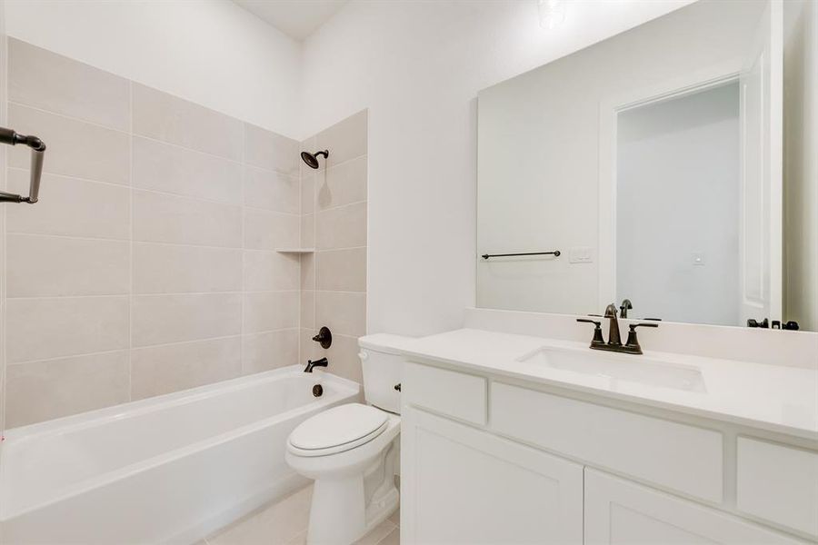 Bathroom with bathtub / shower combination, vanity, and light tile patterned flooring Bathroom with bathtub / shower combination, vanity, and light tile patterned flooring